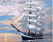 Ship with white sails at sunset